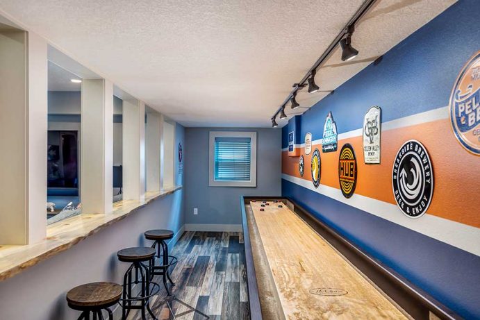 Basement Shuffleboard Room with Bar Stools and Man Cave Signs