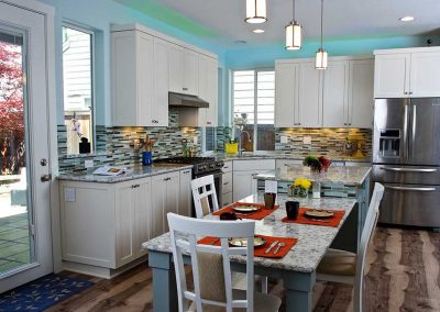 Hi Tech Kitchen with Extended Island Countertop Colorful Tile Backsplash and Lighting Above Cabinets