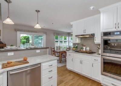 Open Concept Kitchen and Dining with Wood Floors and White Cabinets in Portland