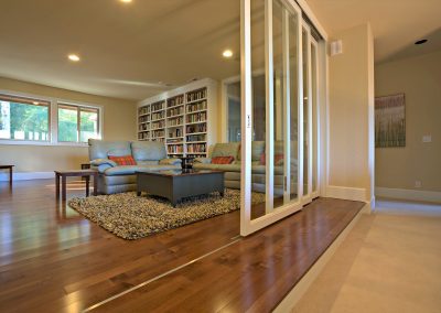 Home Library Addition with Bookcases Couches and Sliding Glass Doors in Lake Oswego